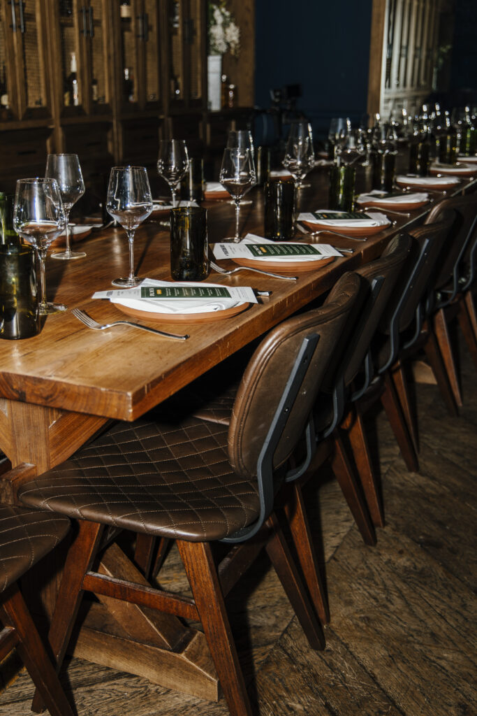 Strategically styled private dinner event with long wooden table, curated place settings, and luxury brand atmosphere in Las Vegas